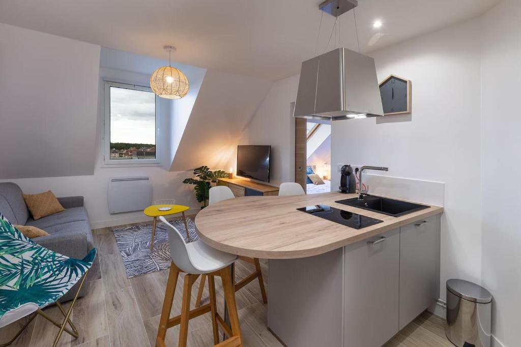 uma cozinha e sala de estar com uma mesa e um sofá em Superbe Appartement 4 pers + 1bb - 3km DisneyLand em Magny-le-Hongre