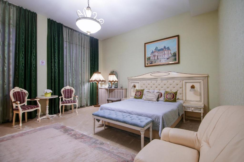 a bedroom with a bed and a table and chairs at Hotel Royal Craiova in Craiova