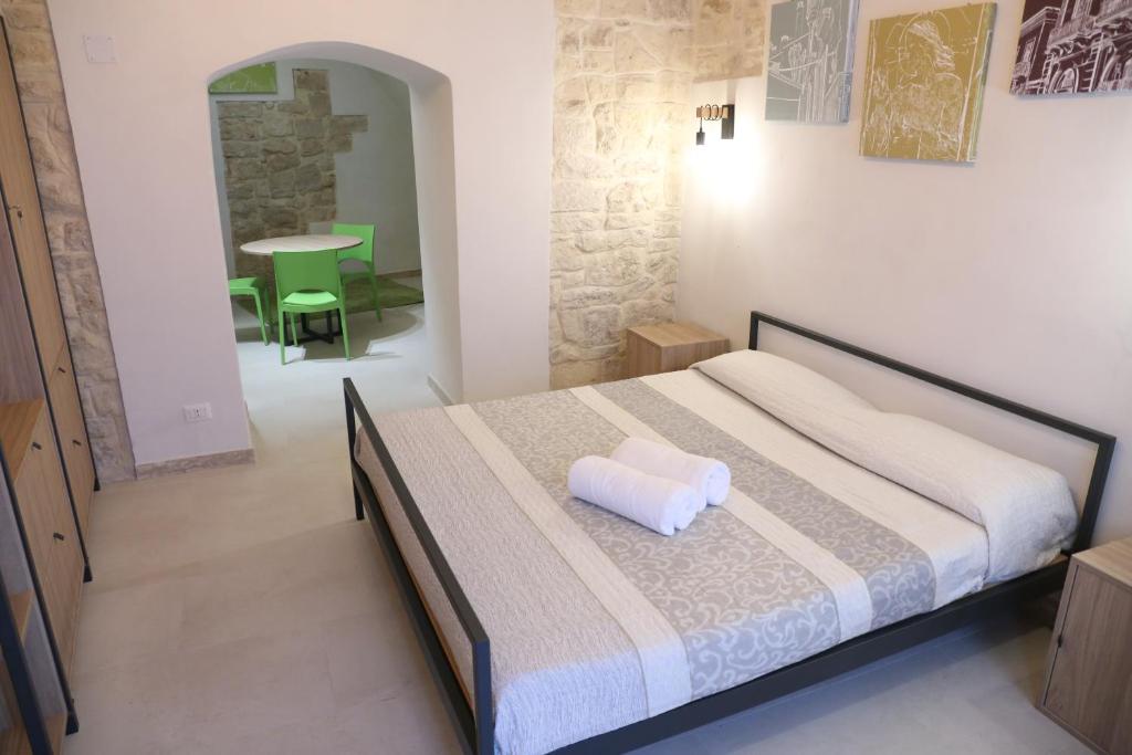 ein Schlafzimmer mit einem Bett mit einem weißen Kissen darauf in der Unterkunft Locus Pendinelli Trani in Trani