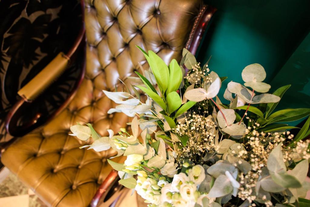 a vase of flowers sitting on a leather chair at Hôtel Le G (ex Le Genève) in Nice