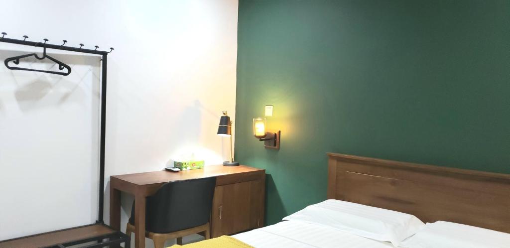a bedroom with a bed and a desk with a lamp at Memory Lane in Colombo
