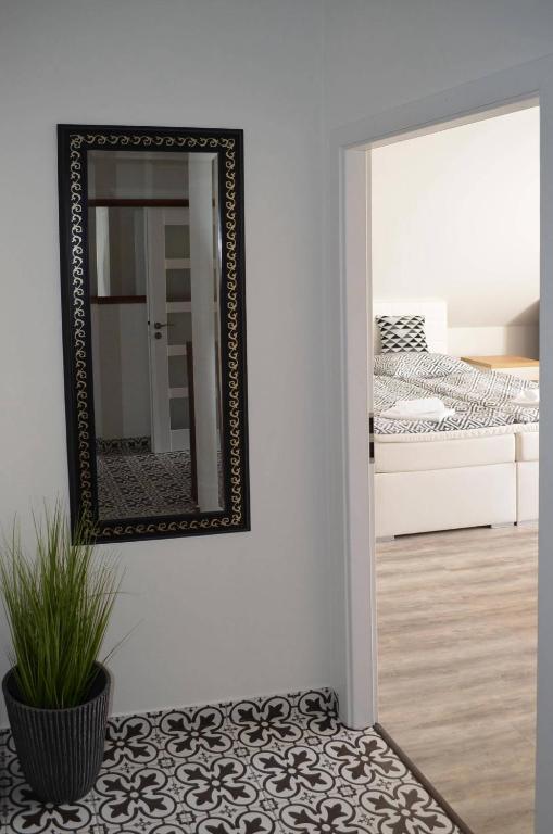 a mirror on a wall next to a bedroom at Hotel Na Baste in Jablonec nad Nisou