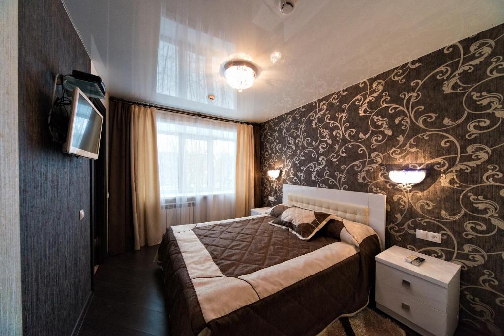 a bedroom with a bed and a wall with a mural at Hotel Shvedka in Bratsk
