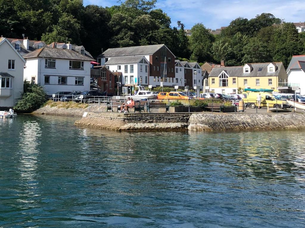 a town next to a body of water with houses at Fowey Landing in Fowey
