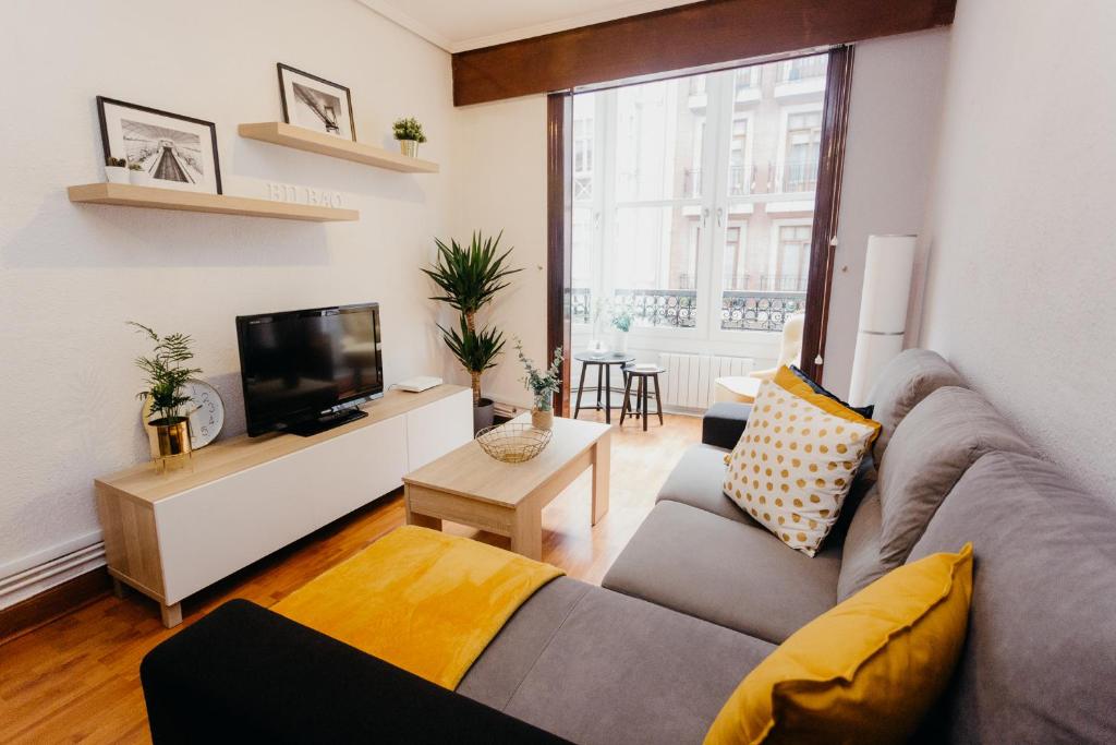 a living room with a couch and a tv at Ubicación excelente cerca de Centro Azkuna in Bilbao