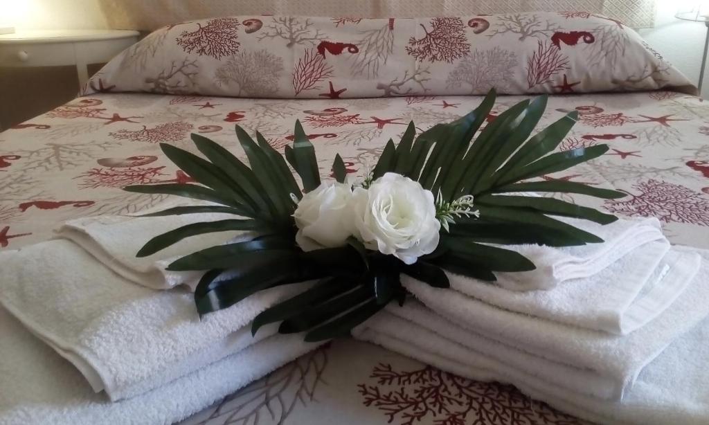un mazzo di fiori bianchi seduto su un letto di CENTRAL ROOM with private bathroom, no smoking a Palau