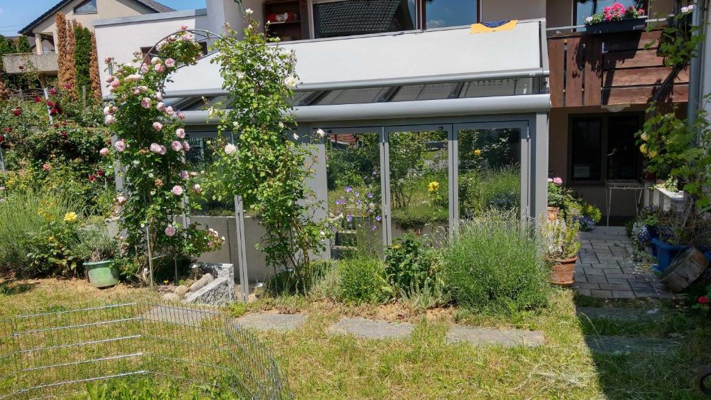 um jardim em frente a uma casa com flores em Inas Ferienwohnungen em Besigheim