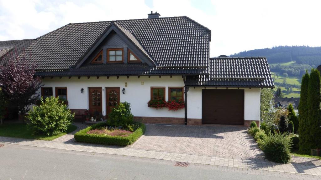 una casa blanca con techo negro en Ferienwohnung Dunja, en Winterberg