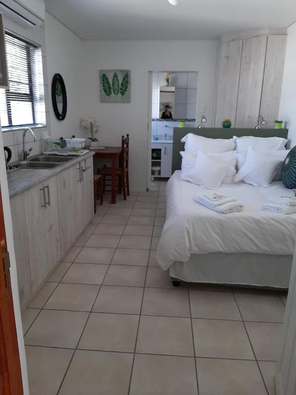 a kitchen and a bedroom with a bed and a sink at Rustverseker Self Catering Accommodation in George