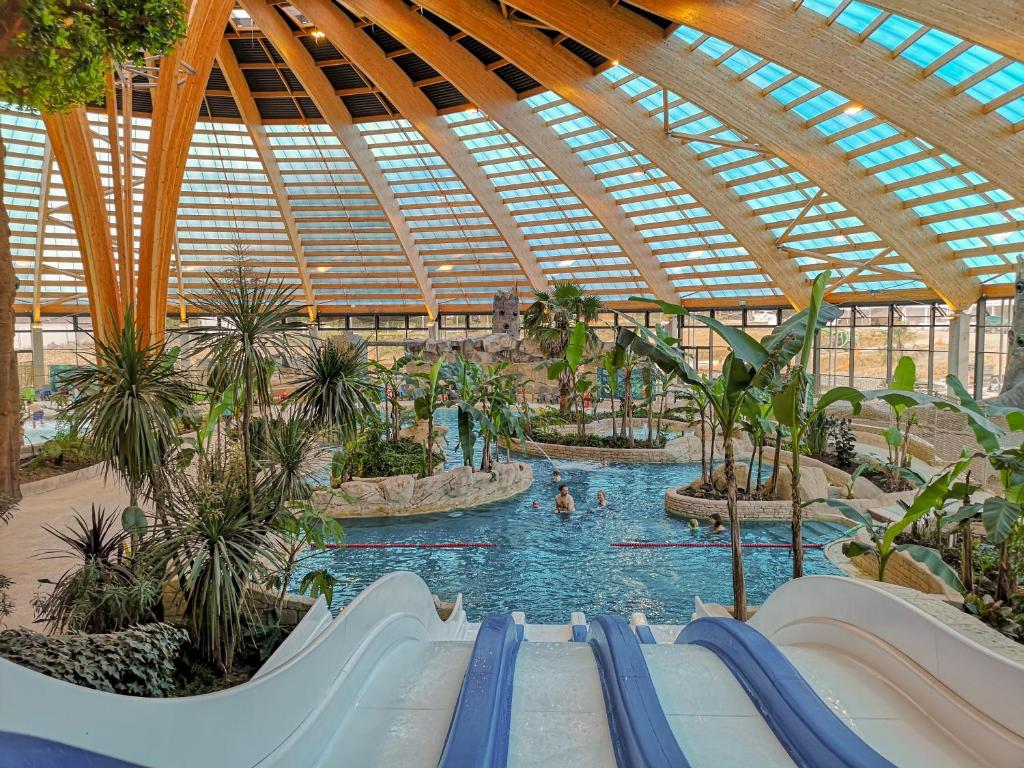 a large indoor swimming pool with people in the water at Insolites, Les Ormes, Epiniac in Epiniac