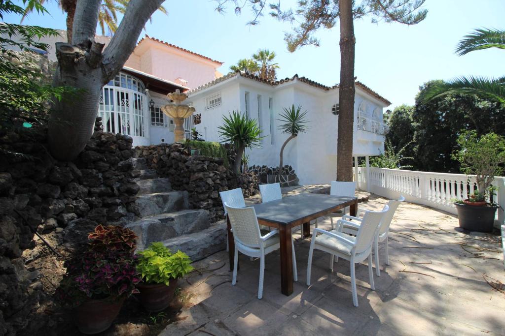 une terrasse avec une table et des chaises devant une maison dans l'établissement Sunny House, Chayofa, à Chayofa