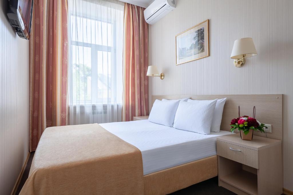 ein Hotelzimmer mit einem Bett und einem Fenster in der Unterkunft Bristol Hotel in Sankt Petersburg