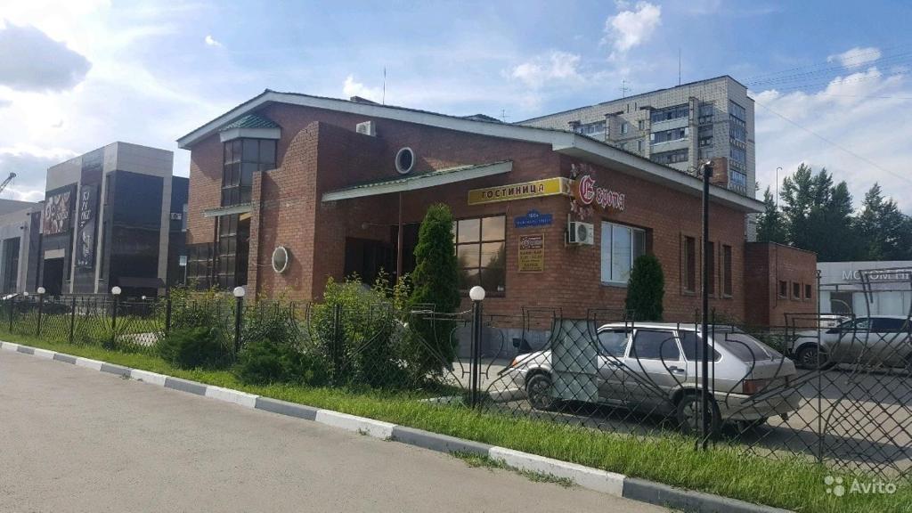 ein Gebäude mit einem davor geparkt in der Unterkunft Europa in Uljanowsk