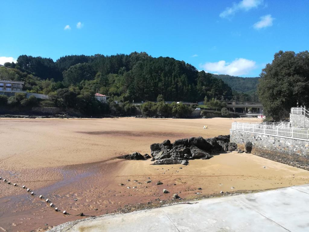 a beach with a bunch of rocks in the sand at Apartamento tranquilo y luminoso in Mundaka