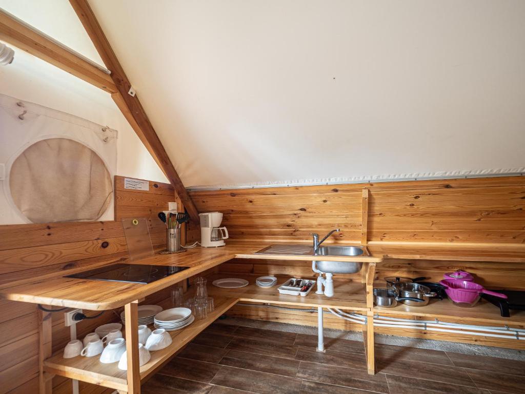 cocina con paredes de madera y lavabo en una habitación en Camping L'Orangeraie, en Cálig