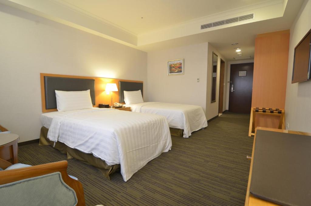 Postel nebo postele na pokoji v ubytování Fuward Hotel Tainan