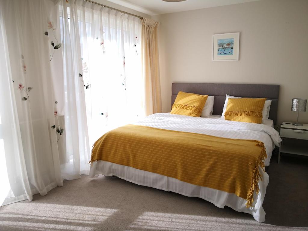 - une chambre avec un grand lit et des oreillers jaunes dans l'établissement Reading New Luxury House Wz Garden&Parking by L&S, à Reading