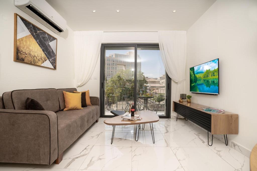 ein Wohnzimmer mit einem Sofa und einem Tisch in der Unterkunft Eshel Suites Even Israel in Jerusalem