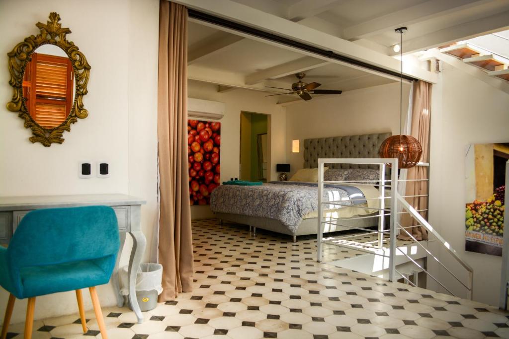a bedroom with a bed and a mirror and a chair at Casa Ebano 967 in Cartagena de Indias