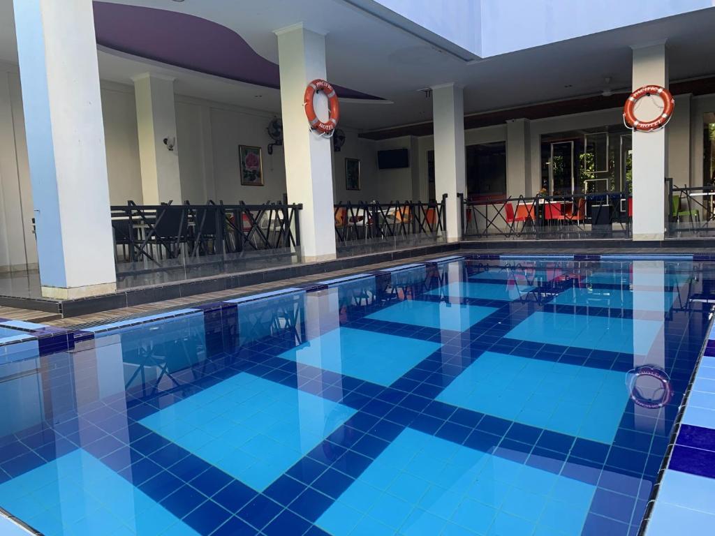 a pool in a hotel with blue tiles at Pacific Hotel Ambon in Ambon