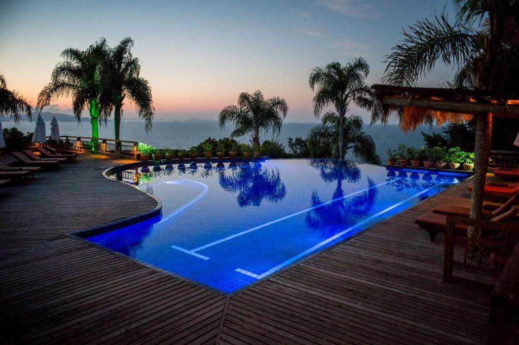 a swimming pool with blue water in a resort at Resort Refúgio do Estaleiro in Porto Belo