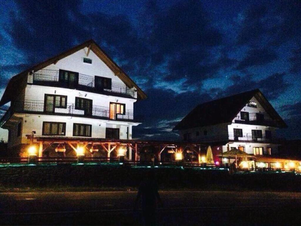 a large building with lights in front of it at night at Pensiunea Casianna & Spa in Păltiniş