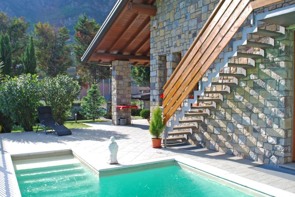 a swimming pool in front of a house with a staircase at B&B I Viandanti in Piancogno