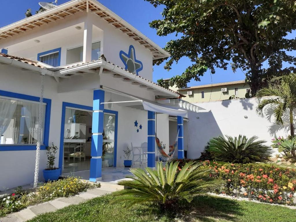 una casa blanca con columnas azules en Estrela Azul Guest House Búzios, en Búzios