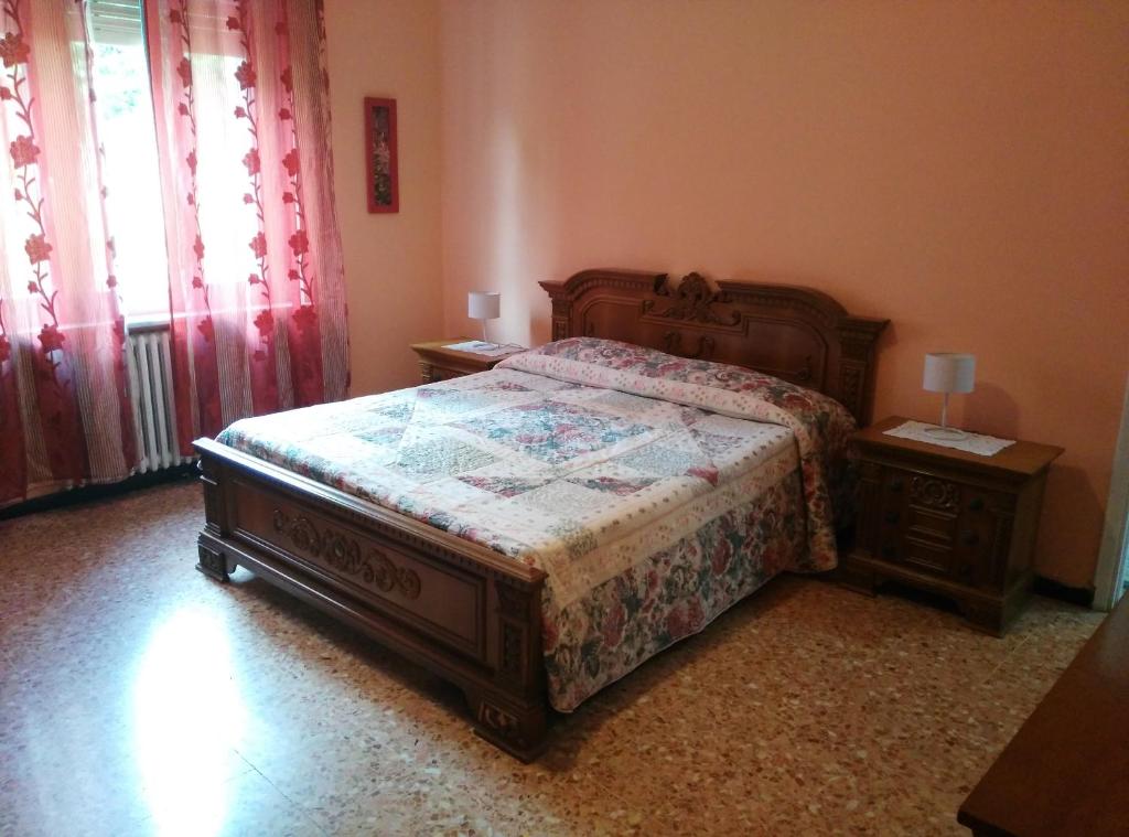 1 dormitorio con 1 cama grande y 2 mesitas de noche en Casa Rosy, en Montiglio