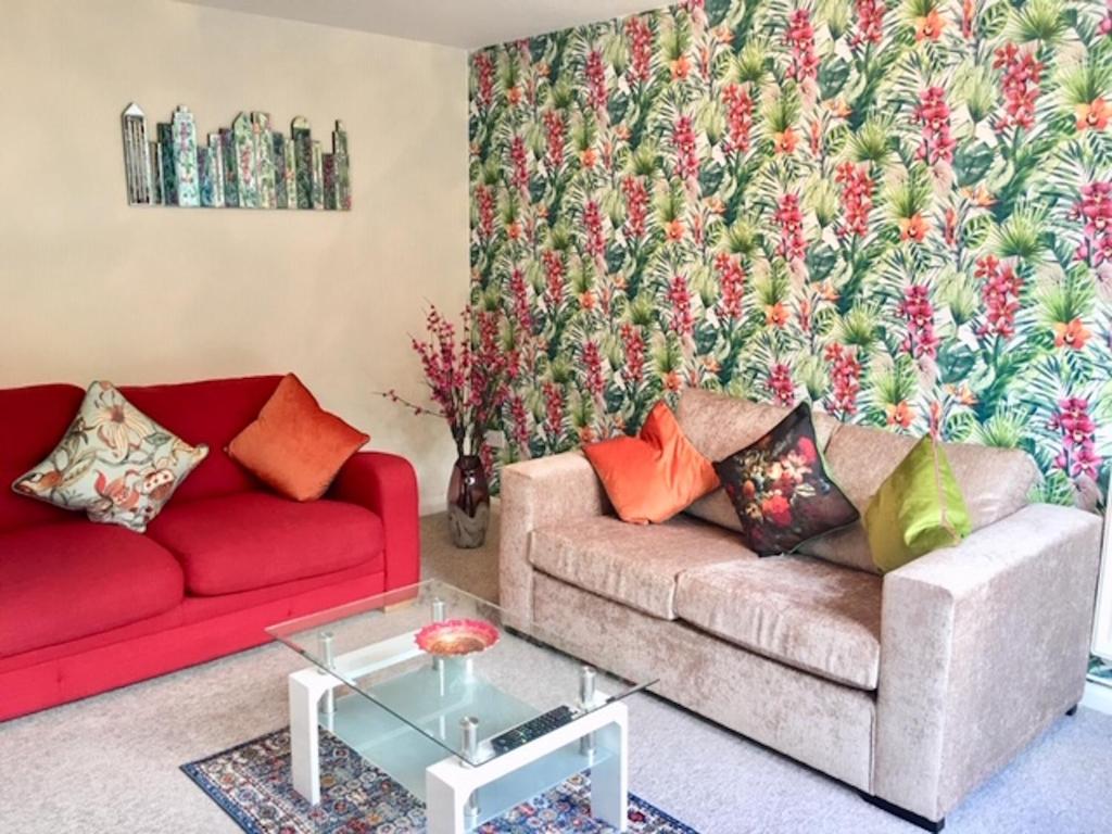 - un salon avec deux canapés et un canapé rouge dans l'établissement Homely Birch Close House with Free Parking,Garden & Sleeps 8, à Cambridge