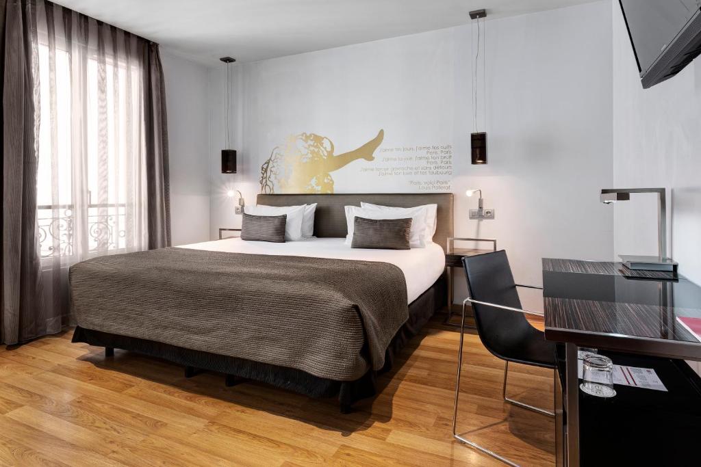 - une chambre avec un grand lit et un bureau dans l'établissement Exe Panorama, à Paris