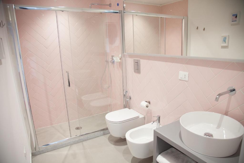 a bathroom with a shower and a toilet and a sink at Cocor Suites & Design in Naples
