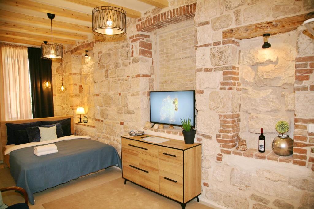 a bedroom with a bed and a stone wall at House Bava in Vis