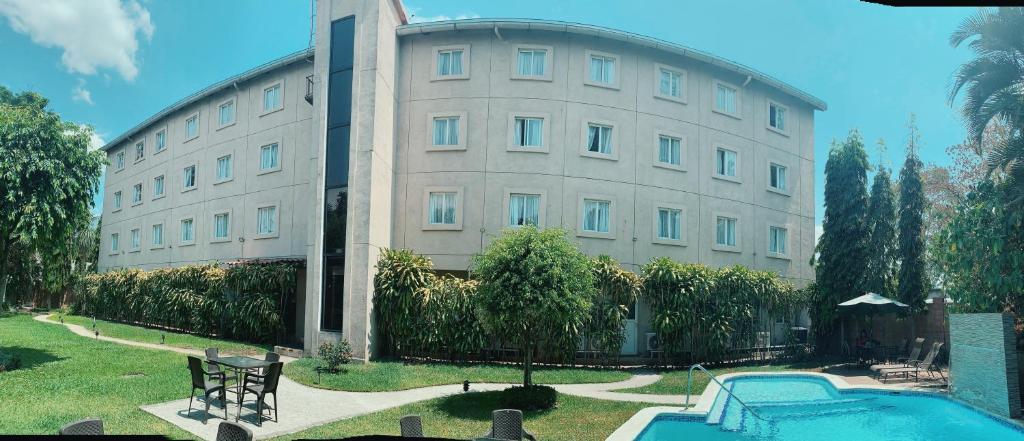 a large building with a swimming pool in front of it at Hotel Gardenia Inn in San Salvador