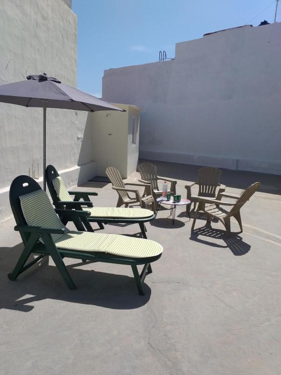 a group of chairs and an umbrella on a patio at Vivienda Vacacional La Aldea de San Nicolas in La Aldea de San Nicolas