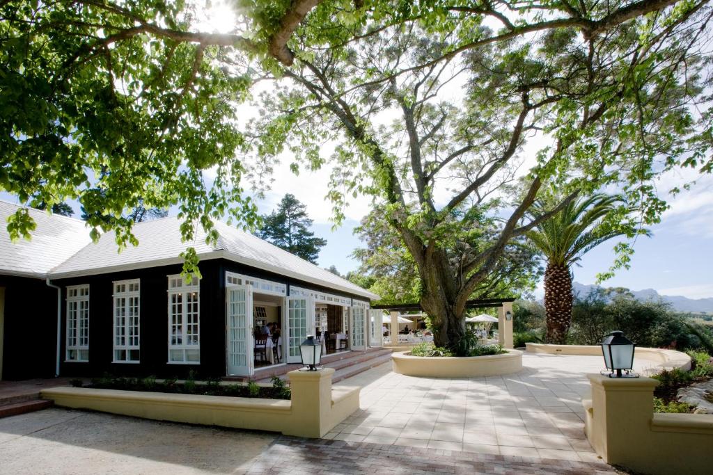 una casa negra con ventanas blancas y árboles en The Devon Valley Hotel, en Stellenbosch