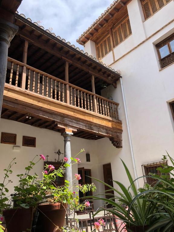 a wooden balcony on a house with plants at Palacio Conde de Cabra in Granada