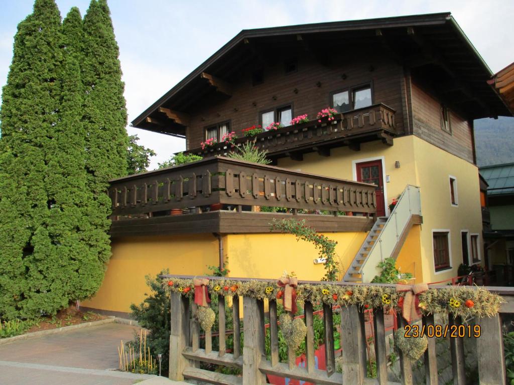 una casa con un balcón con flores. en Haus am Dorfplatz, en Uttendorf