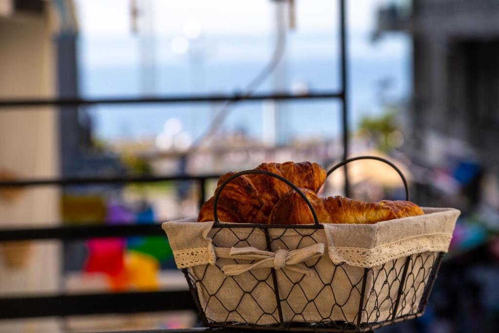 a basket of pastries sitting on top of a table at 100m from the sea in Nice