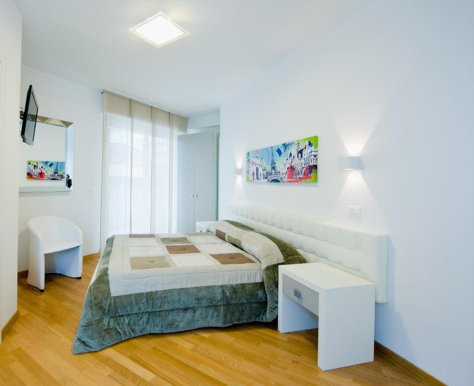 a white bedroom with a bed and a table at Jolie Bed And Breakfast in Pescara