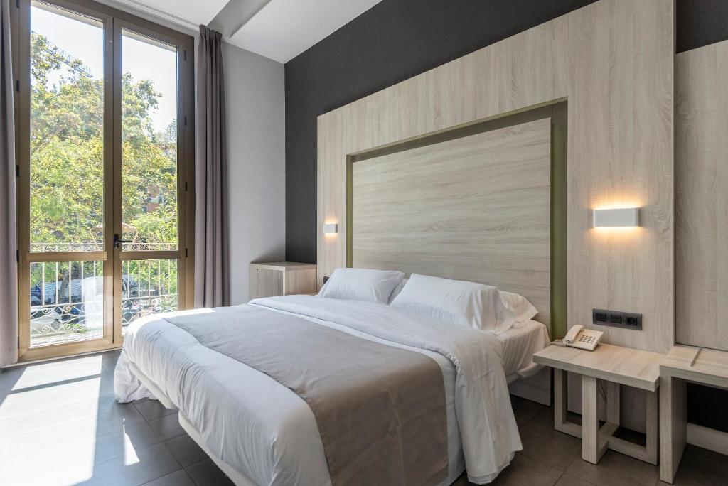 1 dormitorio con cama grande y ventana grande en Plaza Goya Rooms, en Barcelona