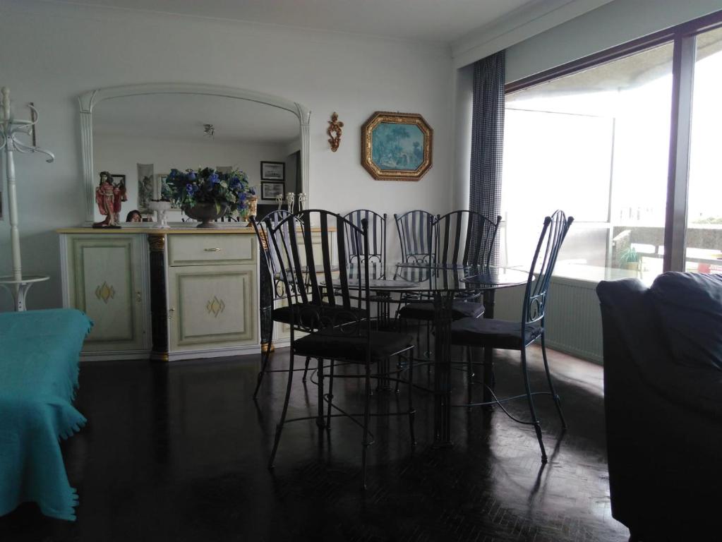 a dining room with a glass table and chairs at Residentie Aldis in Ostend