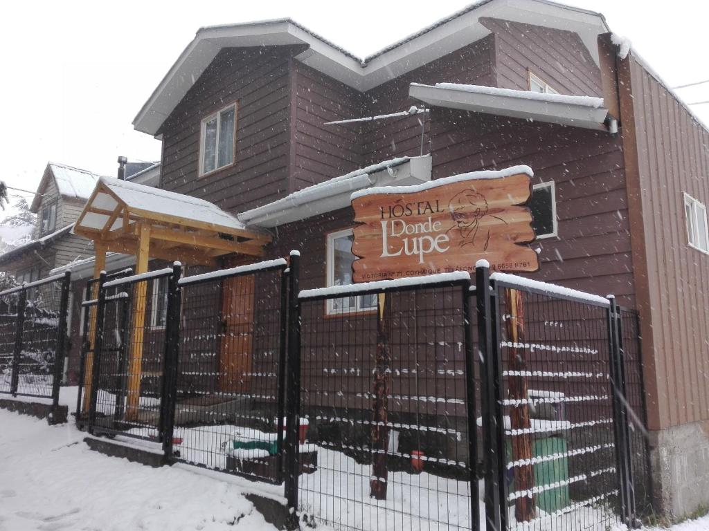 ein Haus mit einem Schild im Schnee in der Unterkunft Donde Lupe in Coihaique