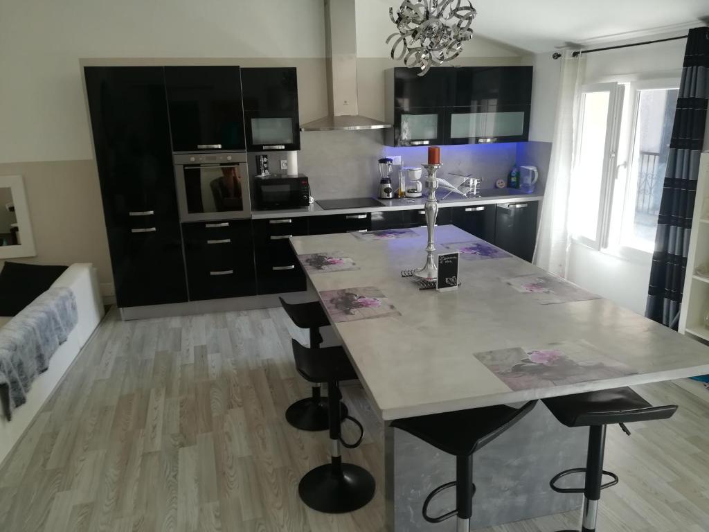 a kitchen with a table and chairs in a room at Black & White in Alignan-du-Vent