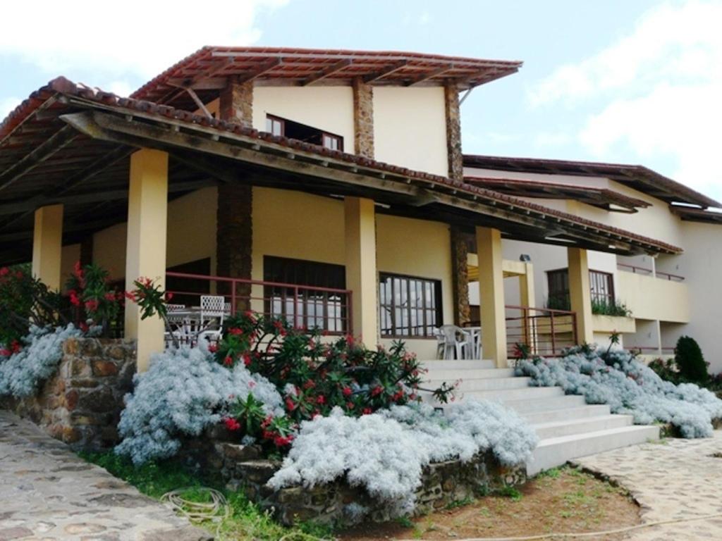 uma casa com flores brancas em frente em Pousada Calugi em Triunfo