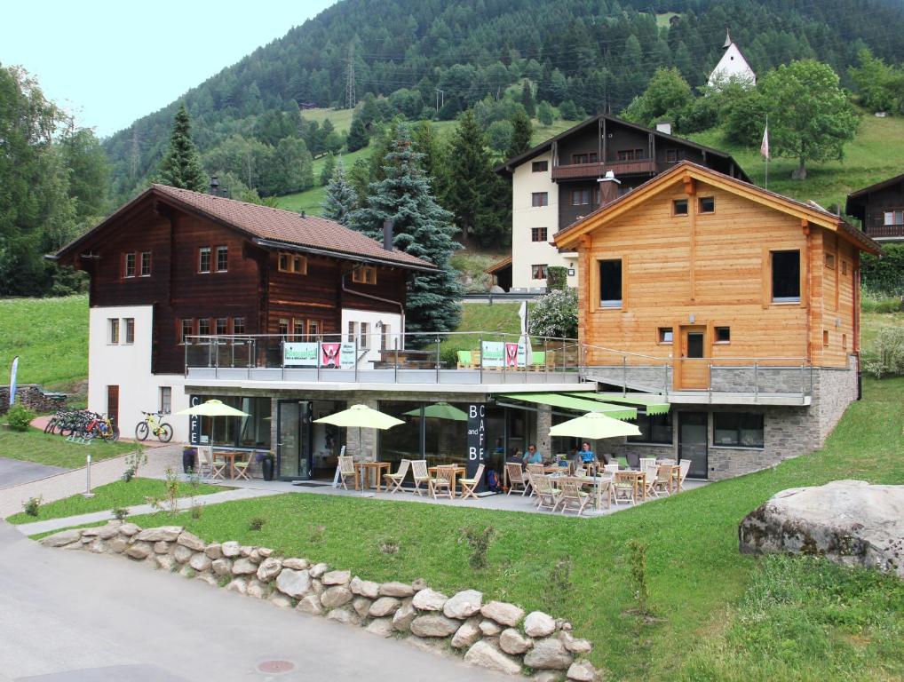 a large building with tables and chairs in front of it at B&B Hängebrigga in Ernen