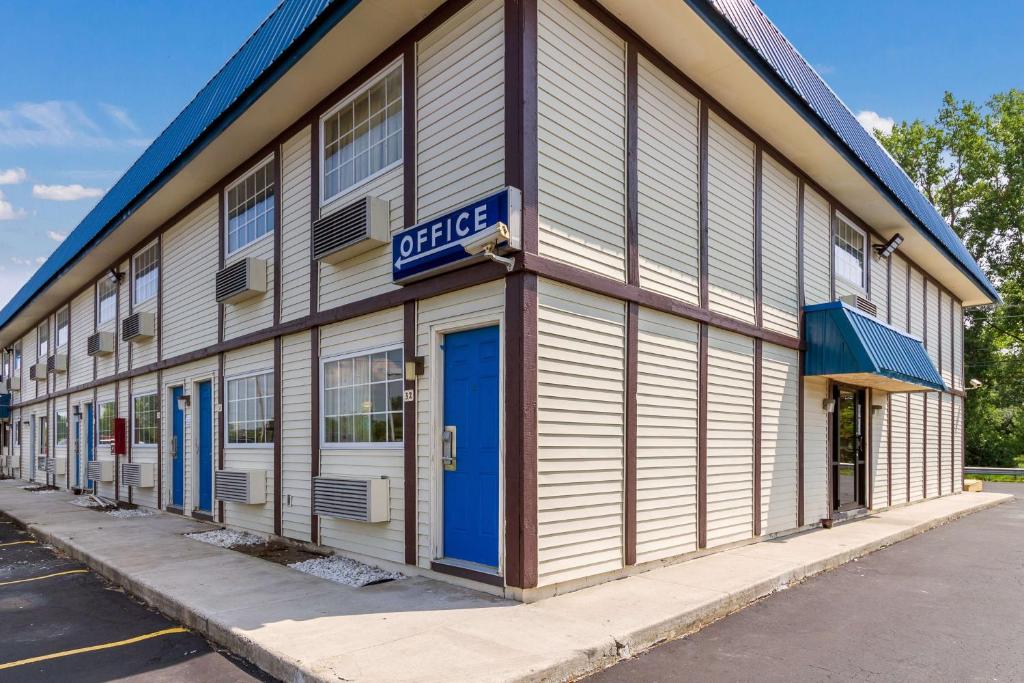 a building with a blue sign on the side of it at Motel 6-Rossford, OH in Rossford