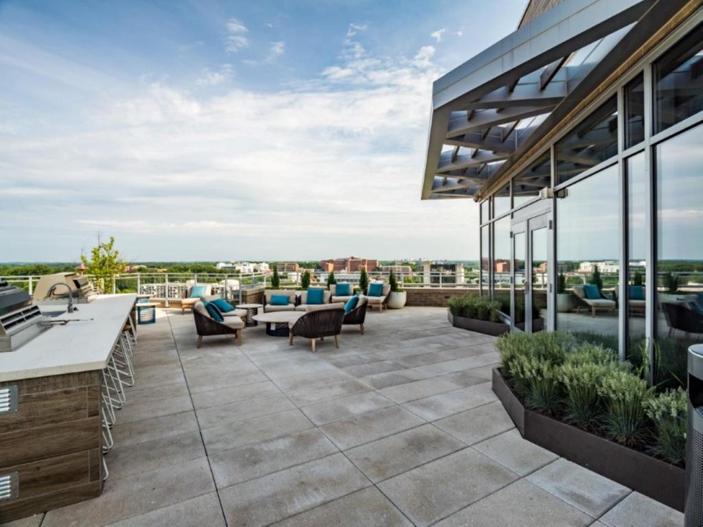 un patio con divani e tavoli su un edificio di Bluebird Suites Near Chevy Chase a Bethesda