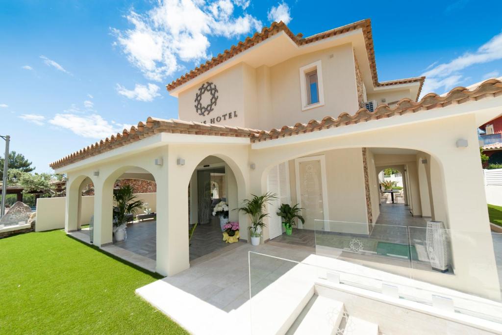 a villa with a lawn in front of it at Suimi's Hotel in Villasimius