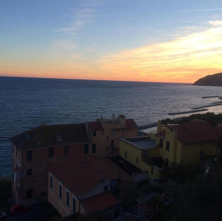 eine Gruppe von Gebäuden und das Meer bei Sonnenuntergang in der Unterkunft Appartamento nel borgo con splendida vista sul mare in Cervo